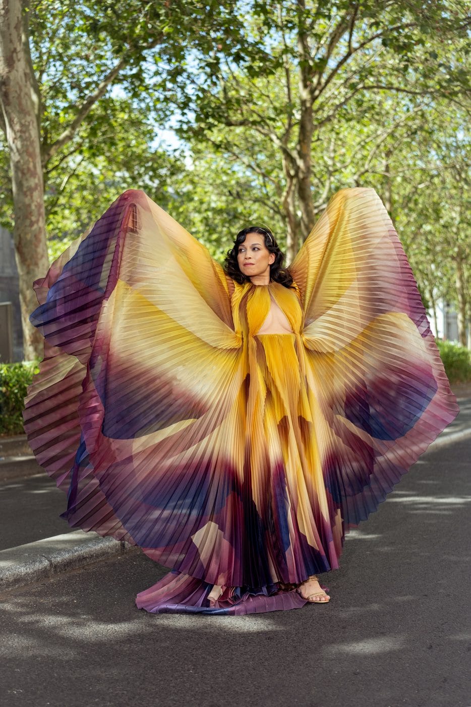 Femme en cape papillon jaune et violette déployée sous les arbres, Jennifer JJ Lee (@by.jjlee), Iris van Herpen