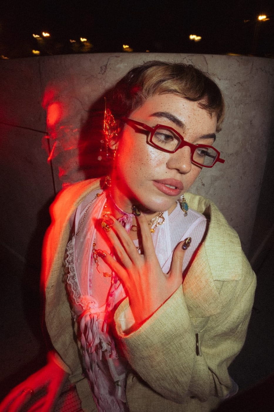 Portrait éclairé au néon rouge, femme en lunettes rouges et foulard imprimé